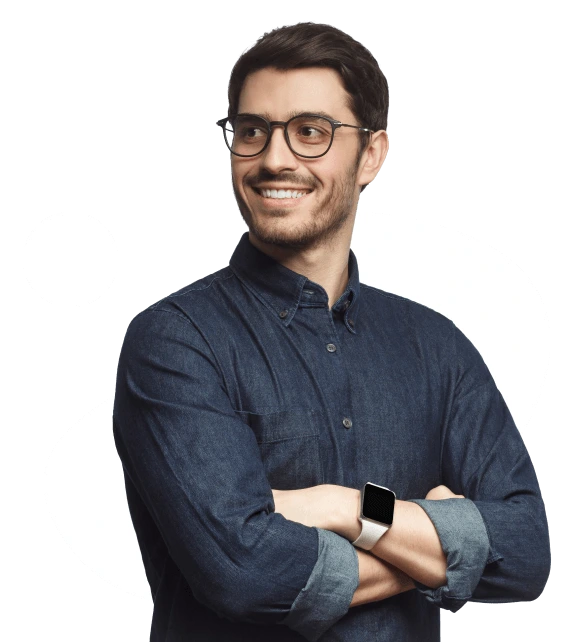 A man wearing a blue shirt and a smartwatch is standing with his arms crossed.